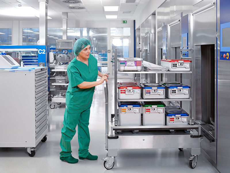 Female CSSD employee with a container trolley