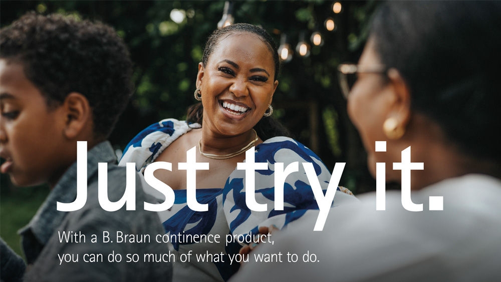 A group of people at an outdoor gathering. The central figure is wearing a white and blue patterned dress. The text on the image reads: "Just try it. With a B. Braun continence product, you can do so much of what you want to."